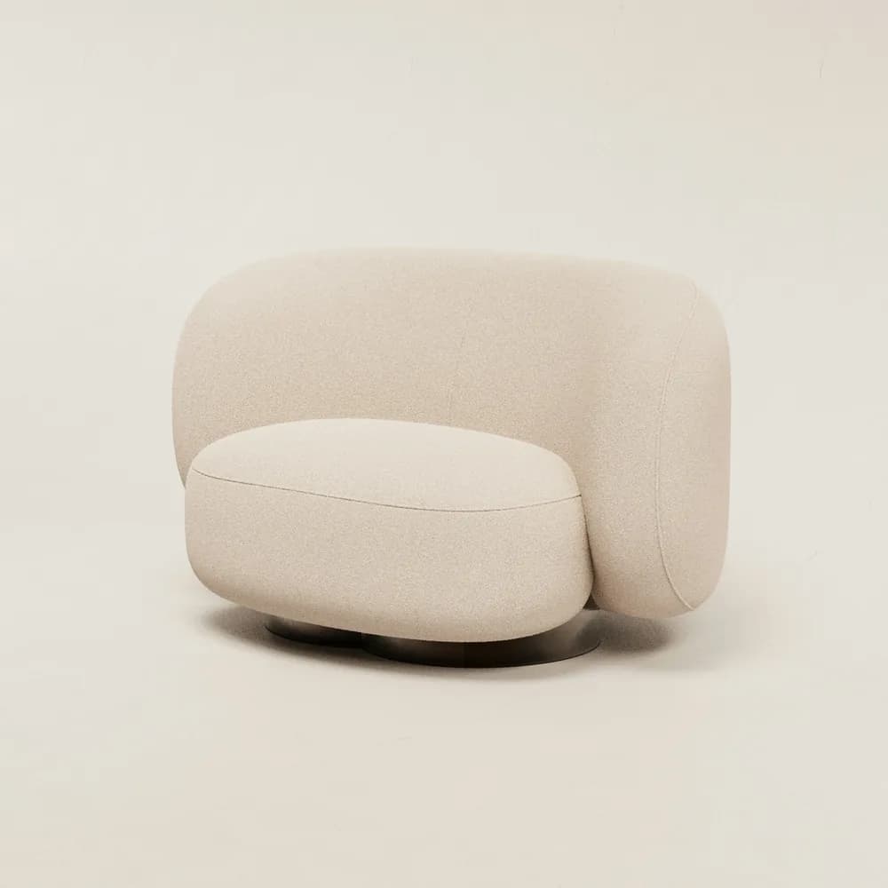 Sillón redondeado en tela bouclé color crudo sobre fondo neutro